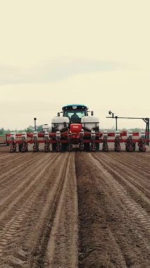 Özel hassas ekicileri olan traktör tarlada çalışıyor, mısır ekimi var, ya da ayçiçeği. Çiftlikte ekim mevsimi. Tarım alanında modern teknolojiler. Hava araştırması, bahar.