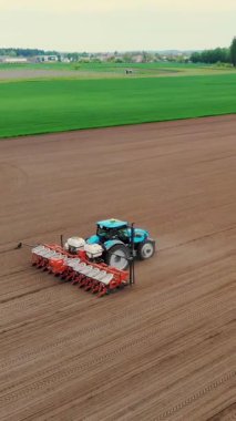 Özel hassas ekicileri olan traktör tarlada çalışıyor, mısır ekimi var, ya da ayçiçeği. Çiftlikte ekim mevsimi. Tarım alanında modern teknolojiler. Hava araştırması, bahar..