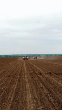 Tarlada özel hassas ekicileri olan iki traktör, mısır ekilir, ya da ayçiçeği. Alandaki sulama sistemi. Çiftlikte ekim mevsimi. Tarım alanında modern teknolojiler. Hava araştırması, bahar.