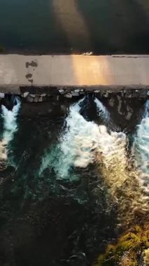 Şelaleden bir Weir 'ın hava görüntüsü. Küçük Barajı olan Huzurlu Nehir, Yeşillik ile çevrili. Gün batımında nehrin üzerinde beton köprü.
