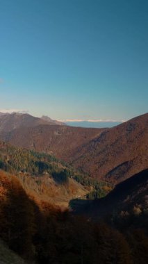 Zaman ayarlı. İtalya, Alpler 'de hareket eden bulutlarla dolu sonbahar manzarası. Bulutların gölgeleri turuncu, kırmızı ve sarı ağaç tepelerinde hareket eder..