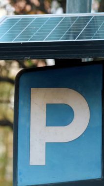 Bir kutuptaki güneş paneli tarafından desteklenen bir park işareti. Çevre dostu yol işaretleri. Yüksek kalite 4k görüntü