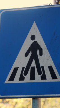 Yaya geçidi tabela panosuna yakın çekim. Arka planda, küçük bir kasabanın sonbahar manzarası..