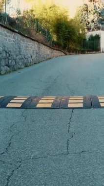 Hız tümseği. Şehirdeki yolda, bir hız tümseği arabaların hareketini yavaşlatır..