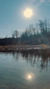 Küçük akıntılı, kayalık bir nehir ve kuru görünümlü bir ormanla çevrili. İtalya 'da kış güneşli bir gün.