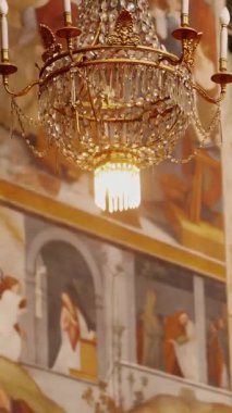 VERCELLI, ITALY, 25 Nisan 2024: Kristal Chandelier ve bir Avrupa kilisesinde süslü freskler ile Zarif Barok İçişleri.