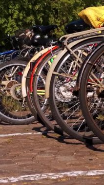 VERCELLI, ITALY, 25 NİSAN 2024: Bir Şehir Bisiklet İstasyonunda güneşli bir günde Parklı Bisikletler Sırası