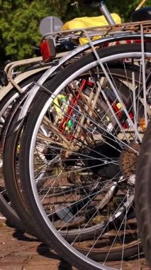 BİELLA, İTALYA, 25 NİSAN 2024: Bisiklet parkına park edilmiş bir sıra bisiklet. Yaz. Parlak güneşli bir gün.