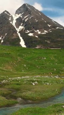 Karla kaplı dağlarla ve yazın kıvrımlı nehirle Alp manzarası