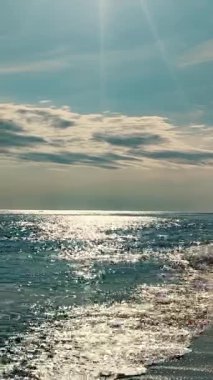 Rocky Cliff ve Sandy Beach Sunny Skies Altında Okyanus Manzarası