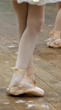 closeup , Bale ayakkabıları genç balerin bacaklar, sivri, bej mayolar, barre yakınında egzersizyapmak, bir bale okulunda eski bir ahşap zemin üzerinde, bale dersi sırasında