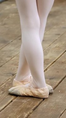 closeup , Bale ayakkabıları genç balerin bacaklar, sivri, bej mayolar, barre yakınında egzersizyapmak, bir bale okulunda eski bir ahşap zemin üzerinde, bale dersi sırasında