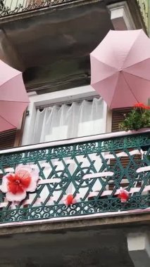 Balkon yaratıcı bir şekilde şemsiye ve çiçeklerle süslenmiş..