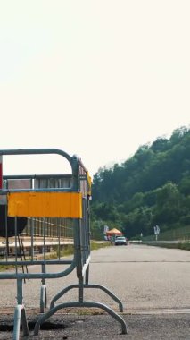 Yol onarımı. Yoldaki çukur. Dikkat! Bariyer, yolda hasar gören kırmızı beyaz şeritli çit. Alp dağlarında büyük bir köprü. yaz günü.