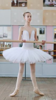 Bale salonunda, beyaz çantalı kız balede nişanlanıyor, Roleve provası yapıyor, parmak uçlarında, sivri ayakkabılarıyla, bale salonundaki korkuluklarda duran genç balerin...