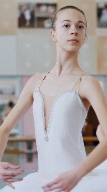 Bale salonunda, beyaz bale etekli iki kız, bale grupları balede meşgul, dönüşleri prova ediyorlar, balerinler bale salonunda korkuluk başında duruyorlar...