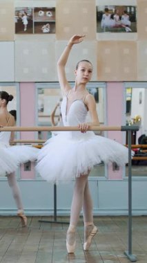 Bale salonunda, beyaz bale etekli kızlar, bale grupları, bale grupları ileri doğru koşar, genç balerinler ayak parmaklarının ucunda bale salonundaki korkuluklarda dururlar...