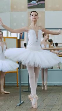 Bale salonunda, beyaz etekli kızlar bale, prova dönüşleri, sivri uçlu ayakkabılar giymiş genç balerinler, bale salonundaki parmaklıklarda zarif bir şekilde dururlar...