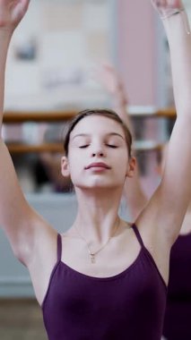 dans salonu, mor tayt içinde genç balerin bölümü de sütyen 3 pozisyon ileri tilt ile gerçekleştirir, kız üzerinde sicim, zarif, ellerini hareket yakın çekim oturuyor.