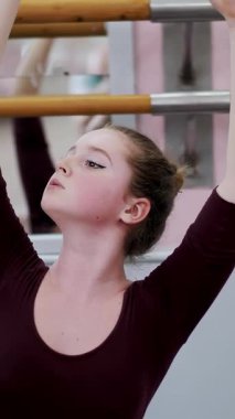 dans salonu, mor tayt içinde genç balerin bölümü de sütyen 3 pozisyon ileri tilt ile gerçekleştirir, kız üzerinde sicim, zarif, ellerini hareket yakın çekim oturuyor.