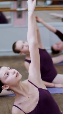 dans salonu, mor tayt içinde genç balerinler bölümü de sütyen 3 pozisyon ileri tilt ile gerçekleştirmek, kızlar el zarif, ayna sınıf hareket. twines üzerinde oturuyorsun..