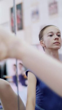 dans salonu, mor tek parça streç giysi içinde genç balerin developpe bir kenara pointe ayakkabılarla gerçekleştirir, bacağını zarif, ayakta barre adlı bale sınıf aynada yakınındaki yukarı yükseltir. yakın çekim.