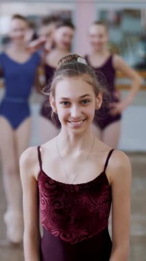 gülümseyerek, incelikle bir bale figürü gerçekleştirme bir genç kız balerin bir leylak bale tek parça streç giysi içinde portresi..