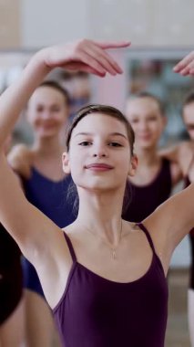 gülümseyerek, incelikle bir bale figürü gerçekleştirme bir genç kız balerin bir leylak bale tek parça streç giysi içinde portresi..