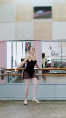 Dans salonunda, siyah taytlı genç balerin pas courru, pointe yapıyor, bale sınıfında zarifçe hareket ediyor.,.