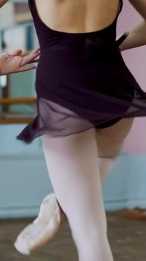 Mor tek parça streç giysi içinde genç balerin zarif belirli bale egzersizleri, beşinci pozisyonlarda bale sınıf pirouettes gerçekleştirir..