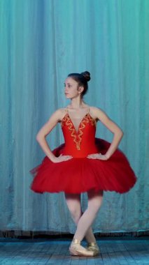 eski tiyatro salonu sahnesinde bale prova. Kırmızı bale ayakkabıları, tutu ve pointe içinde genç balerin dans ediyor sissone basit zarif belirli bale hareket.