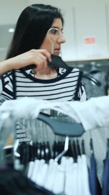 Alışverişe. Satın alma. Esmer kadın ve genç kız, mağazadan ya da pazar yerinden yeni şık kıyafetler seçiyorlar. Alışveriş merkezi. Moll. Süpermarket. İndirim, indirim.