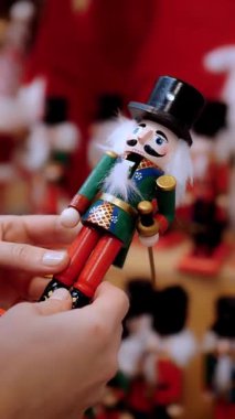 Fındıkkıran oyuncağı, asker. Noel alışverişi. Adil. Yakın plan. Kadınlar Noel aksesuarlarını ve süslemeleri dükkanda seçiyor. Mutlu Noeller ve mutlu yıllar. Alışveriş merkezi
