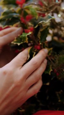 Noel alışverişi, dekorasyon, fuar. Yakın plan. Kadın dükkanda Noel için aksesuar seçiyor. Noel süsü olarak Evergreen 'in yapay dalları. Mutlu Noeller ve mutlu yıllar. Alışveriş merkezi.