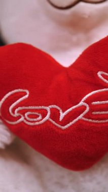 Sevgililer Günün kutlu olsun. Aşk konsepti. Yakın plan. yumuşak oyuncak ayı, kırmızı kalpli ve üzerine aşk kelimesi yazan. Hediyeler, festival dekoru, Sevgililer Günü için süslemeler..