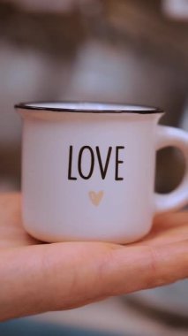 Sevgililer Günü. Yakın plan. Küçük kahve fincanı, avuç içine aşk yazma. Sevgililer gününde hediye, duyguların ve sevginin ifadesi olarak. Aşk konsepti.