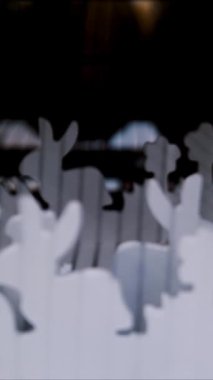 Paskalya panayırı. Yakın plan. Çimlerin üzerinde kontrplaktan yapılmış Paskalya tavşanlarının dekoratif beyaz heykelcikleri bir mağazada sergileniyor. Geleneksel Avrupa paskalya dekoru ve dekorasyonları.