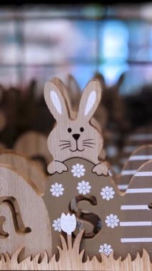 Paskalya indirimi. Paskalya süslemeleri ve dükkandaki ev için hediyeler. Geleneksel Paskalya tavşanları ve yumurtalarla ahşap, kontraplaktan oyulmuş dekoratif Paskalya.