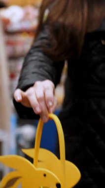 Paskalya panayırı. Yakın plan. Süslü Paskalya hediyeleri, kadın ellerinde tavşan çantaları. Paskalya alışverişi süpermarkette ya da markette. Geleneksel Avrupa paskalya dekoru ve dekorasyonları.