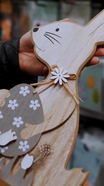 Paskalya panayırı. Yakın plan. Paskalya süslerini tutan kadın elleri. Paskalya tavşanının komik biblosu. Katolik Paskalyası için geleneksel Avrupa dekorasyonu