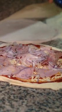 Pizza restoranın mutfağında hazırlanıyor. Şef İtalyan pizzasına peynir serper. Yakın plan yiyecek.