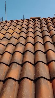 Güneşli bir günde Çatı Tiling 'in gelişimi. Geleneksel Mavi Gök Altında Terracotta Çatı Döşemeleri