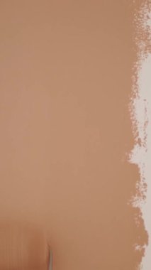 Duvar resmi. Su bazlı boya. Paten boyama. Onarım. Yakın plan. Boya silindiri kullanarak beyaz duvarı pembeye boyamak. Dairede, odada, evde, dairede tadilat yapıyor. Tamamlama ve inşaat işi