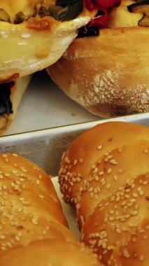 Fırın ürünleri. Sokak yemeği. Yakın plan. Taze pişmiş ciabatta, baget, hamurda sosis, ekmek ve çörekler, farklı dolgulu poğaça kruvasanları. Tatlı hamur işleri. Ev yapımı fırın..