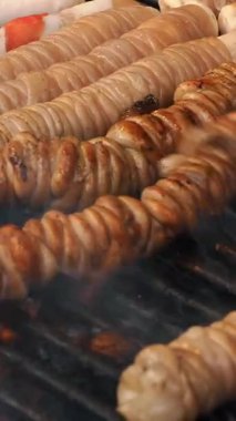 Şişte kızarmış et. Şiş kebap ya da şiş kebap. Yakın plan. Izgara sulu domuz eti ve tavuk etiyle pişirilmiş. Küçük kebaplar, ahşap şişler üzerinde et parçaları, ateşte kızartılmış..