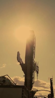 Dönen sarkacı sürüyorum. Koşu eğlenceleriyle dolu güzel bir park. Dönen atlıkarınca. Gün batımı. Lunaparkta salıncakta sallan.