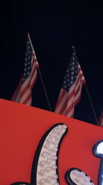 Amerikan bayrakları geceleyin rüzgarda dalgalanıyor. Amerikan bayrağı. Amerika Birleşik Devletleri 'nin ünlü bayrağını sallayarak.