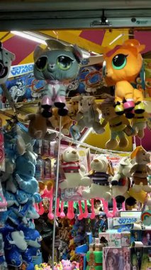 BIELLA, İtalya, 11 Haziran 2022: oyuncuları ayartmak için bir sürü sevimli oyuncakla dolu bir panayır tezgahı. Lunaparkın Gece Işıkları. Gece Eğlence Fuarı. Parlayan ışık.