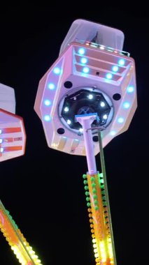 Işıklı atlıkarınca. Antika atlıkarıncanın inanılmaz renkli yanıp sönen ışığı. Eğlence Parkı 'nda Popüler Sandalye Dönüşü. Parlayan ışık.