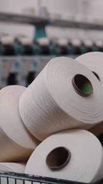 Bir sepetteki iplik maşaları. İplik üretimi. İplik yapma süreci. Dönen yapım. Tekstil fabrikası ekipmanı. Tekstil fabrikası. Makaraları geri sarmak ya da pamuklu ya da yün ipliklerle bobinleri sarmak.